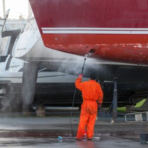 Man cleaning a boat with a pressure washer