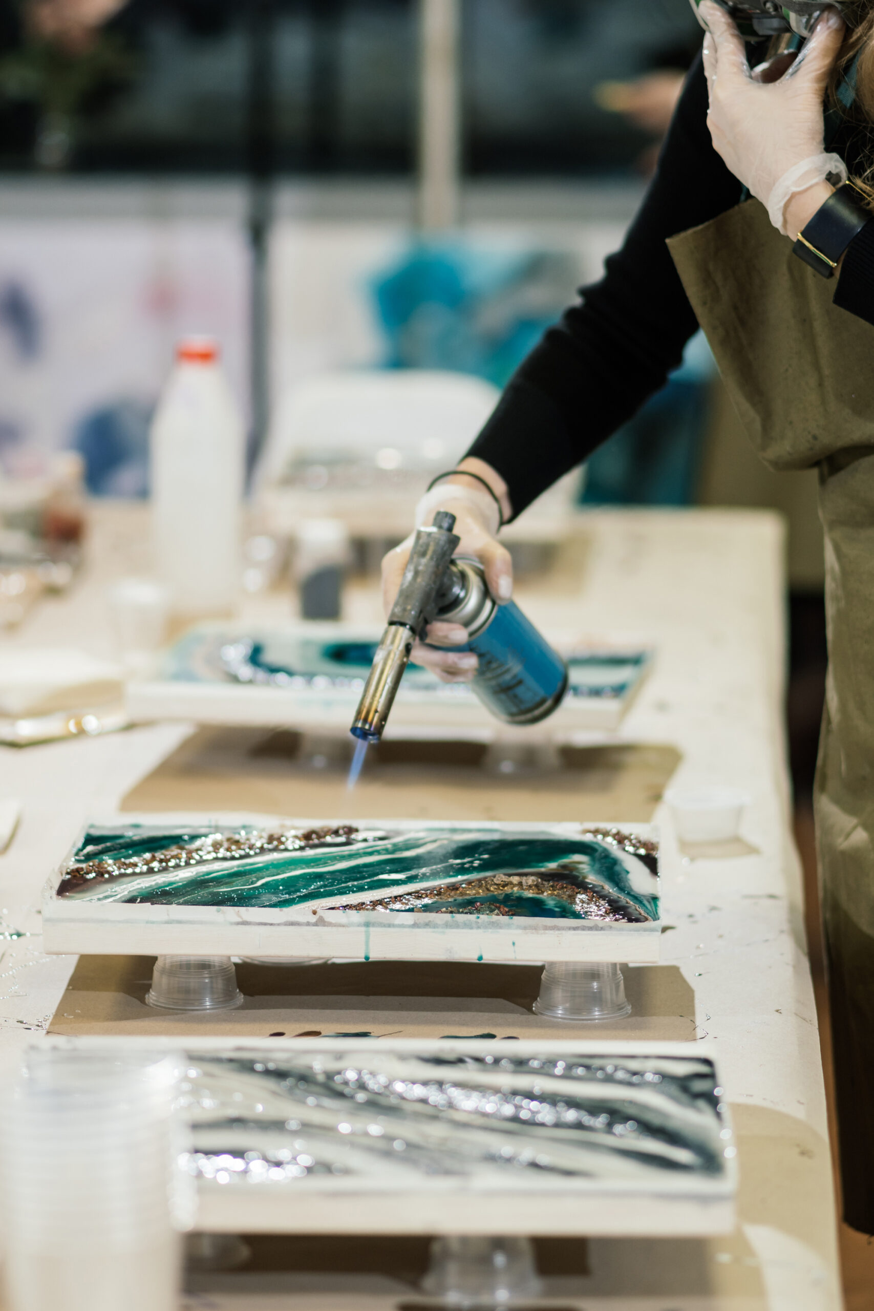 lady using blow torch on resin to remove bubbles